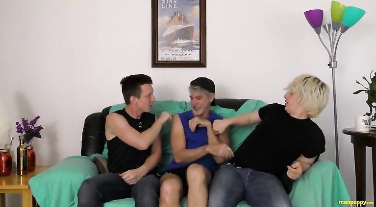 Two guys hold down and tickle an older man